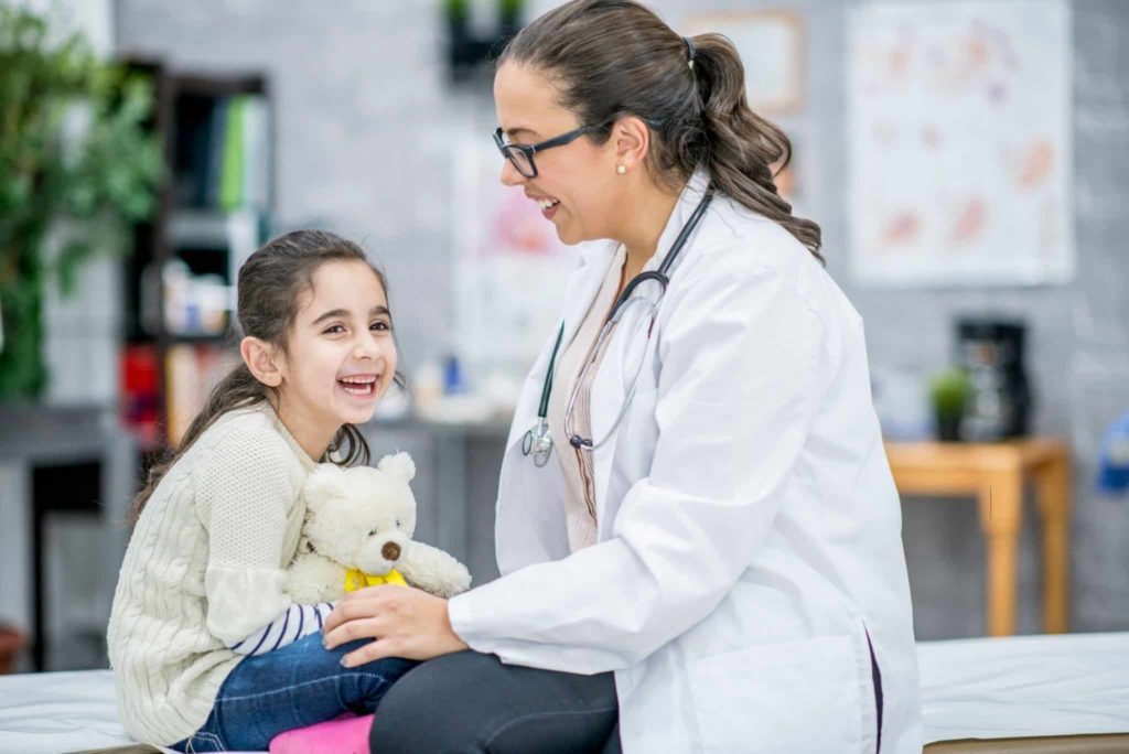 Enfant souriant avec le pédiatre et neuropédiatre